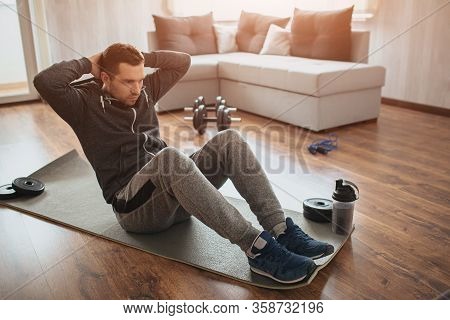 Young Ordinary Man Go In For Sport At Home. Hardworking Freshman Sit On Mat And Do Abs Excercise. No