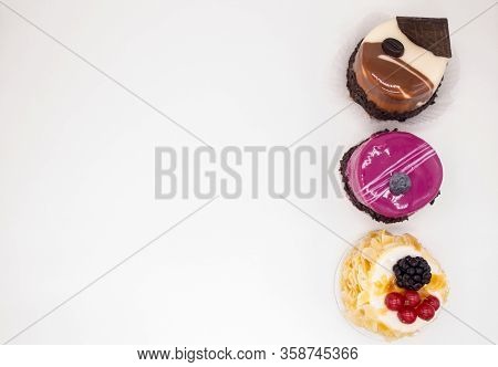 Top View Of Three Cakes On A White Background:coffee Cake With A Grain Of Coffee, Chocolate, Cream C