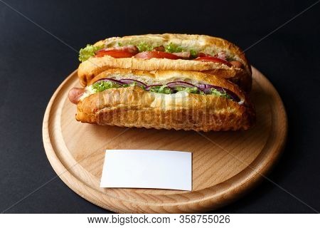 Two Hot Dogs Lying On The Wooden Plate. Mock Up.