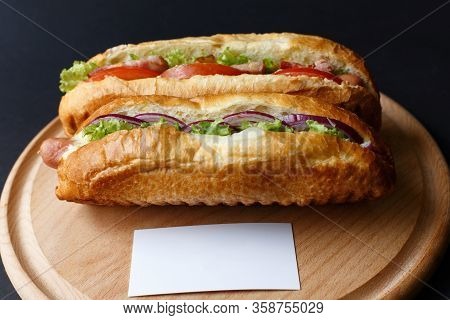Two Hot Dogs Lying On The Wooden Plate. Mock Up.