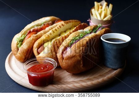 Three Hot Dogs, Ketchup, Coffee, French Fries Lying On The Wooden Plate.  Mock Up.