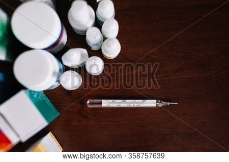 Medical Preparations Pills And Thermometer Stand On The Table