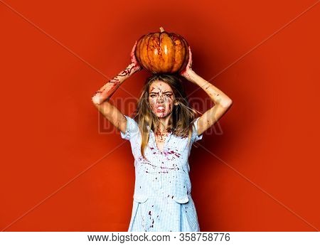 Girl With Pumpkin. Zombie. Blood Lust. Halloween Woman On Red Background Isolated. Full Of Blood