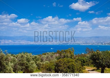 Summer Seascape On Cypus. View To The Bay With Green Grove In Front And Blue Clouded Sky. View From 