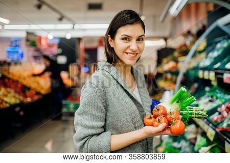 Young Woman Shopping In The Supermarket Grocery Store.buying Organic Vegetables Sustainable Produce.