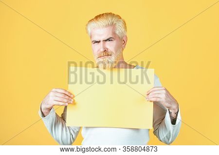 Man Holding A Blank Sheet Of Paper, Isolated On Yellow Background