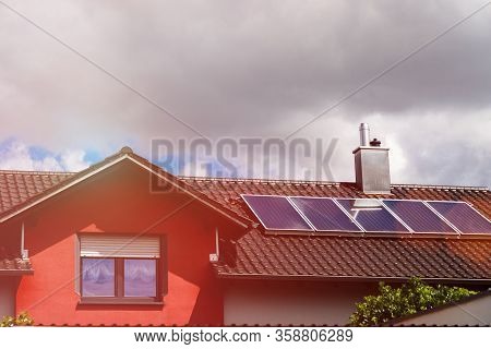 Several Solar Panels On The Roof Of A House In Cloudy Weather. The Concept Of Poor Location, Bad Wea