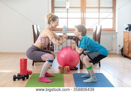 Family doing squats on floor at home during Covid-19 curfew staying fit