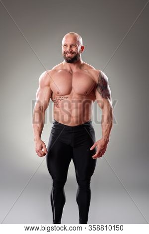Sexy Muscular Bodybuider Posing On The Gray Background