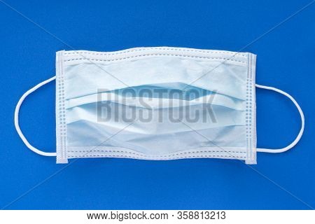 Typical 3 Ply Surgical Face Mask With Rubber Ear Straps To Cover The Mouth And Nose