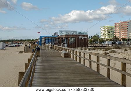 Monte Gordo, Portugal - November 18, 2019:  Holidaymakers Using The Boardwalk Over The Soft Sand Dun