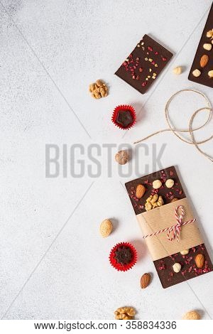 Handmade Dark Chocolate Bars With Nuts And Dried Fruits And Candies On White Background. Top View, C