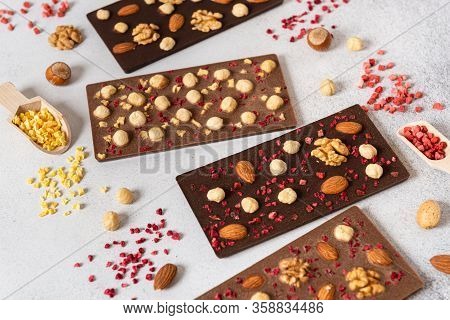 Dark And Milk Chocolate Bars With Nuts And Dried Fruits On Light Background. Homemade Organic Chocol