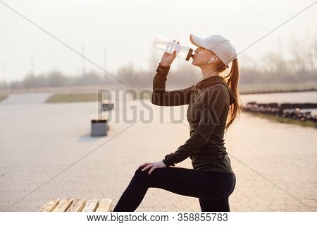 Beautiful Girl At Morning Workout Drinks Water From A Bottle