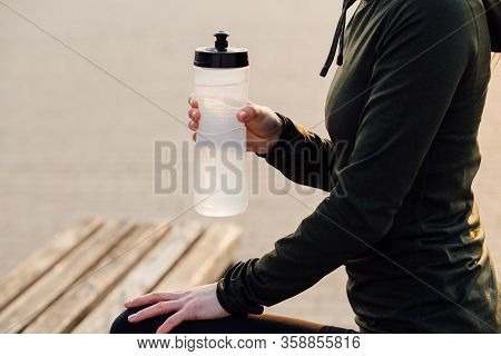 Beautiful Girl At Morning Workout Drinks Water From A Bottle