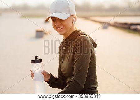 Beautiful Girl At Morning Workout Drinks Water From A Bottle