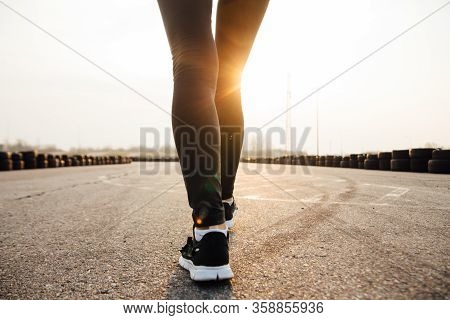 Morning Run Of A Young Girl On The Street In Black Leggings And Sneakers