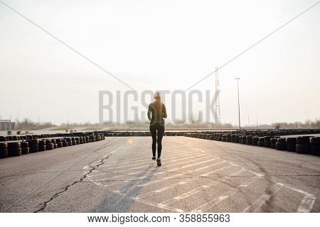 Morning Run Of A Young Girl On The Street In Black Leggings And Sneakers