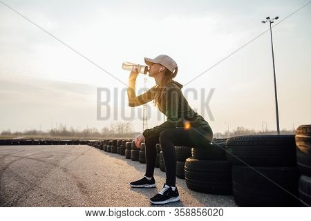 Beautiful Girl At Morning Workout Drinks Water From A Bottle