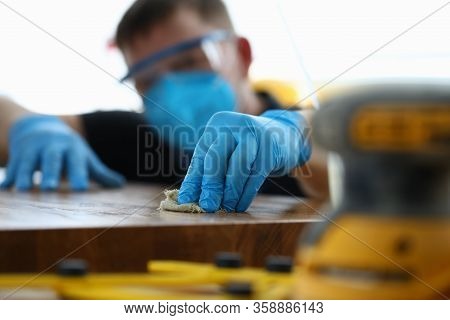 Carpenter In Gloves Cleans Polishes Wooden Surface. Joiner Polish Wooden Surface Canvas On Table. Pr