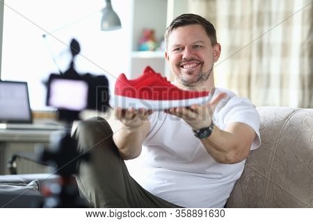 Man In An Apartment Is Filming Review New Sneakers. Guy During Self-isolation In Apartment Works Rem