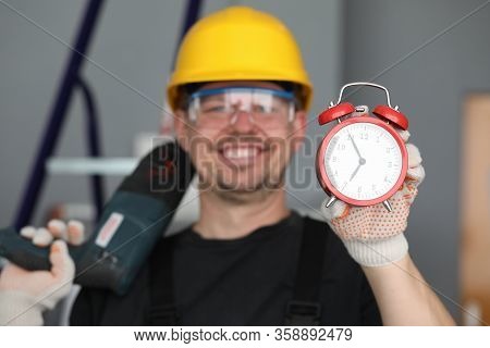 Male Builder Helmet Laughing Showing Alarm Clock. Performance Repair Work Within Specified Period. N