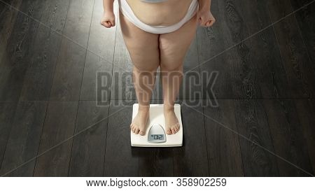 Angry Woman Standing On Scales To Measure Weight, Unsuccessful Diet, Failure