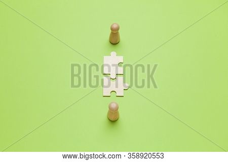 Wooden Figures With Pazzles On Green Background. Agreement Between Business Mans, Cooperation And De
