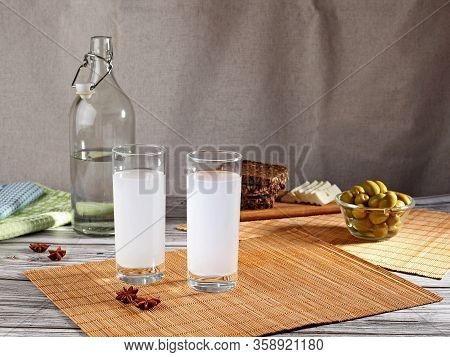 Traditional Greek Ouzo In Two Glasses With Appetizers. With Copy Space