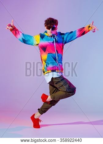 Guy Dancing Contemporary Dance In Studio. Neon Light Grey Background. Acrobatic Bboy Dancer. Break D