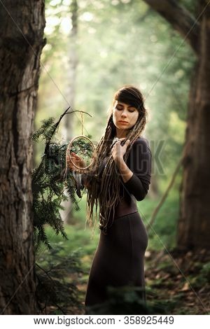 Vertical Portrait Of Beautiful Young Woman With Dreads In Dark Dress With Traditional American India