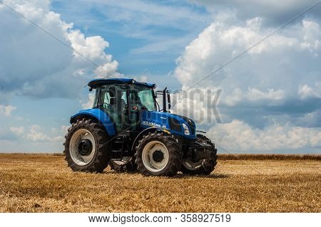 Blue Tractor New Holland In Motion At Demonstration Field Site At Agro Exhibition Tractor Working On