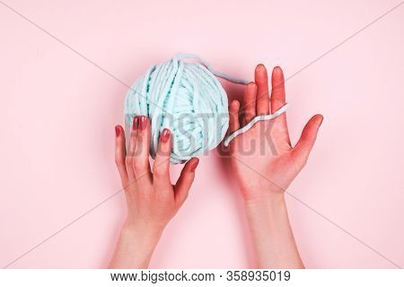 Woman Hands With Mentol Yarn Ball On Light Pink Background
