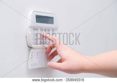 Woman Hand Entering Alarm System Password Of An Apartment, House Of Business Office. Surveillance An