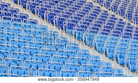Empty Blue And Dark-blue Seats In The Stadium Before The Match.