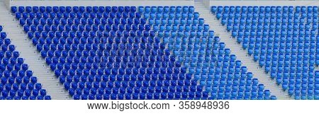 Empty Blue And Dark-blue Seats In The Stadium Before The Match.