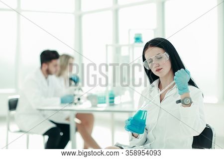 Close Up.woman Scientist Takes A Sample Of The Liquid .