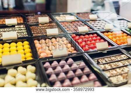 Assortment Of Candies Desserts On Cafe Showcase. Variety Of Sweets With Different Flavours Nuts In S