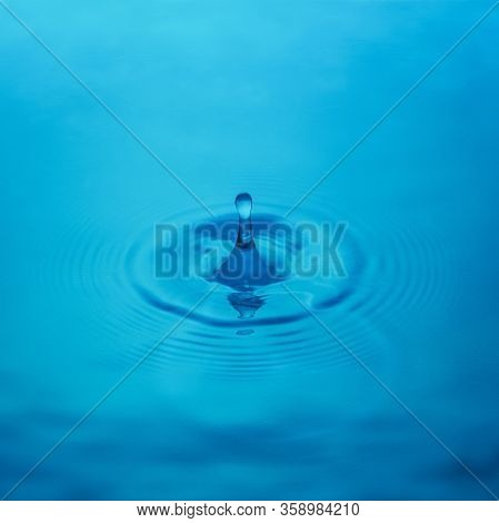 Splash From A Drop Of Water On A Blue Background, Close-up. Selective Focus.