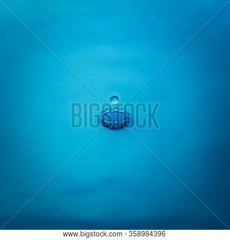 Splash From A Drop Of Water On A Blue Background, Close-up. Selective Focus.