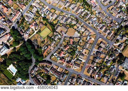 An Aerial View Directly Above A Suburban Community On The Outskirts Of A City With Intertwining Road