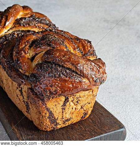 Freshly Baked Brioche/babka With Poppy Seeds And Chocolate On A Wooden Board. Braided Dessert Bread.