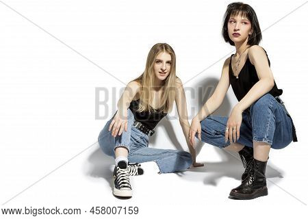 Youth Lifestyle Concepts. Portrait Of Young Caucasian Lesbian Couple Sitting On Hunkers Together Aga