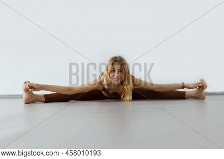 Young Attractive Fitness Woman Performing Twine , Upavista Konasana
