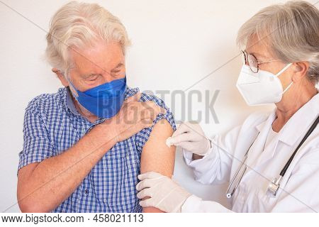 Doctor Giving Injection To Senior Caucasian Man, Old Retired Receiving Booster Of Covid 19 Vaccine, 