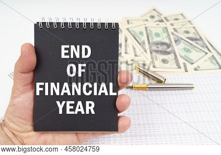 Business Concept. In The Man's Hand Is A Notepad With The Inscription - End Of Financial Year, In Th