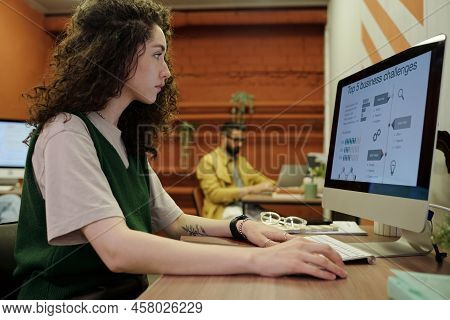 Young Serious Businesswoman Analyzing Finnacial Data On Computer Screen