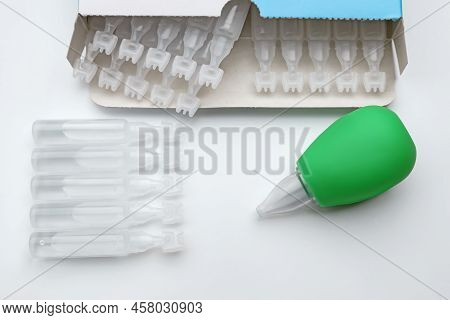 Single Dose Ampoules Of Sterile Isotonic Sea Water Solution And Nasal Aspirator On White Background,