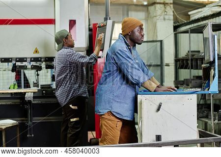 African Operator Setting The Data On Computer Machine For Cutting During His Work At Factory
