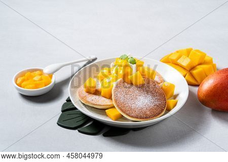 Delicious Japanese Souffle Pancake With Dice Mango And Jam On White Table Background.